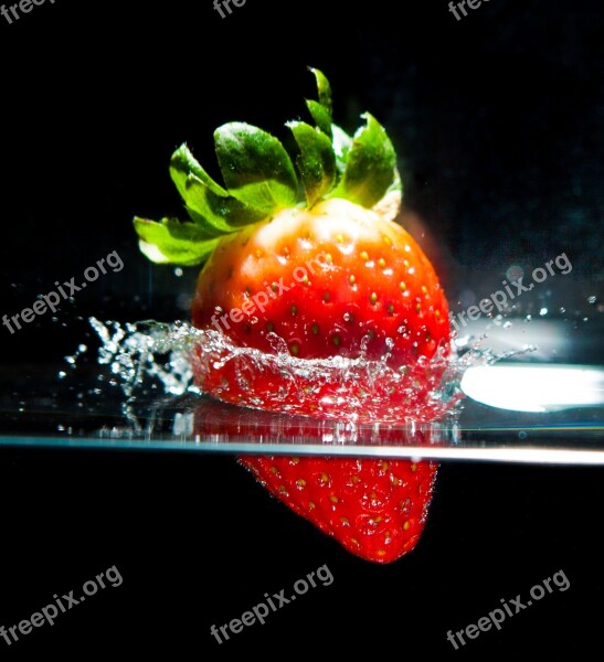 Strawberry In The Water Motion Spray The Dark Background